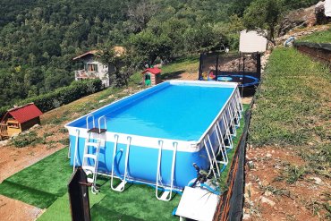 Piscina fuori terra tubolare Laguna Large 125: installazione rapida su prato artificiale, struttura stabile e resistente, ideale per giardini collinari.