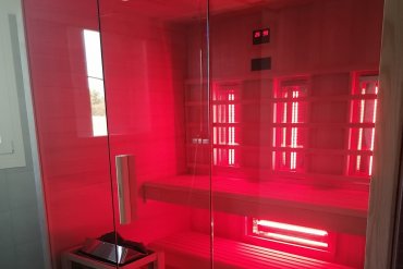Sauna finlandese multifunzione moderna in vetro e legno con cromoterapia LED multicolore, ideale per casa o spa. Perfetta per relax, detox e benessere quotidiano.