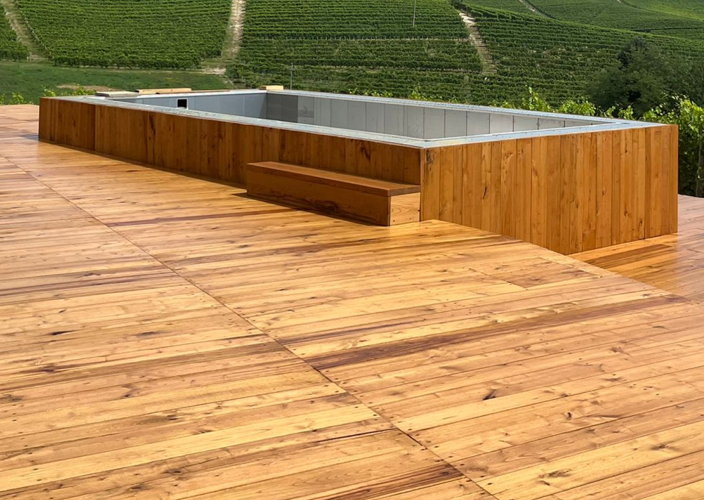 Piscina autoportante rettangolare ASTREA 7,8 metri con deck in legno in mezzo ai vigneti