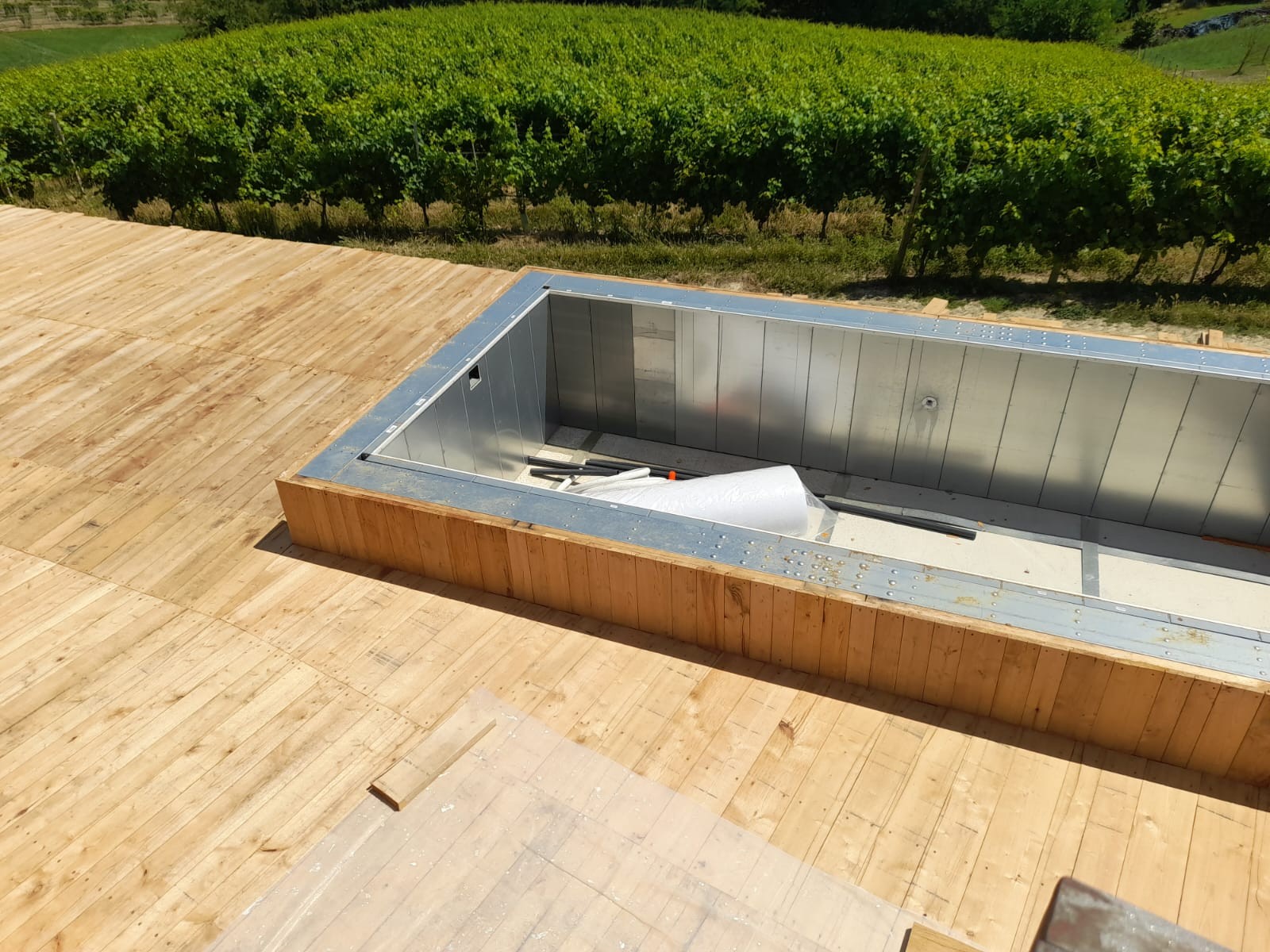 Piscina autoportante ASTREA rettangolare da 7x8 metri con deck in legno, installazione fuori terra su terrazza panoramica