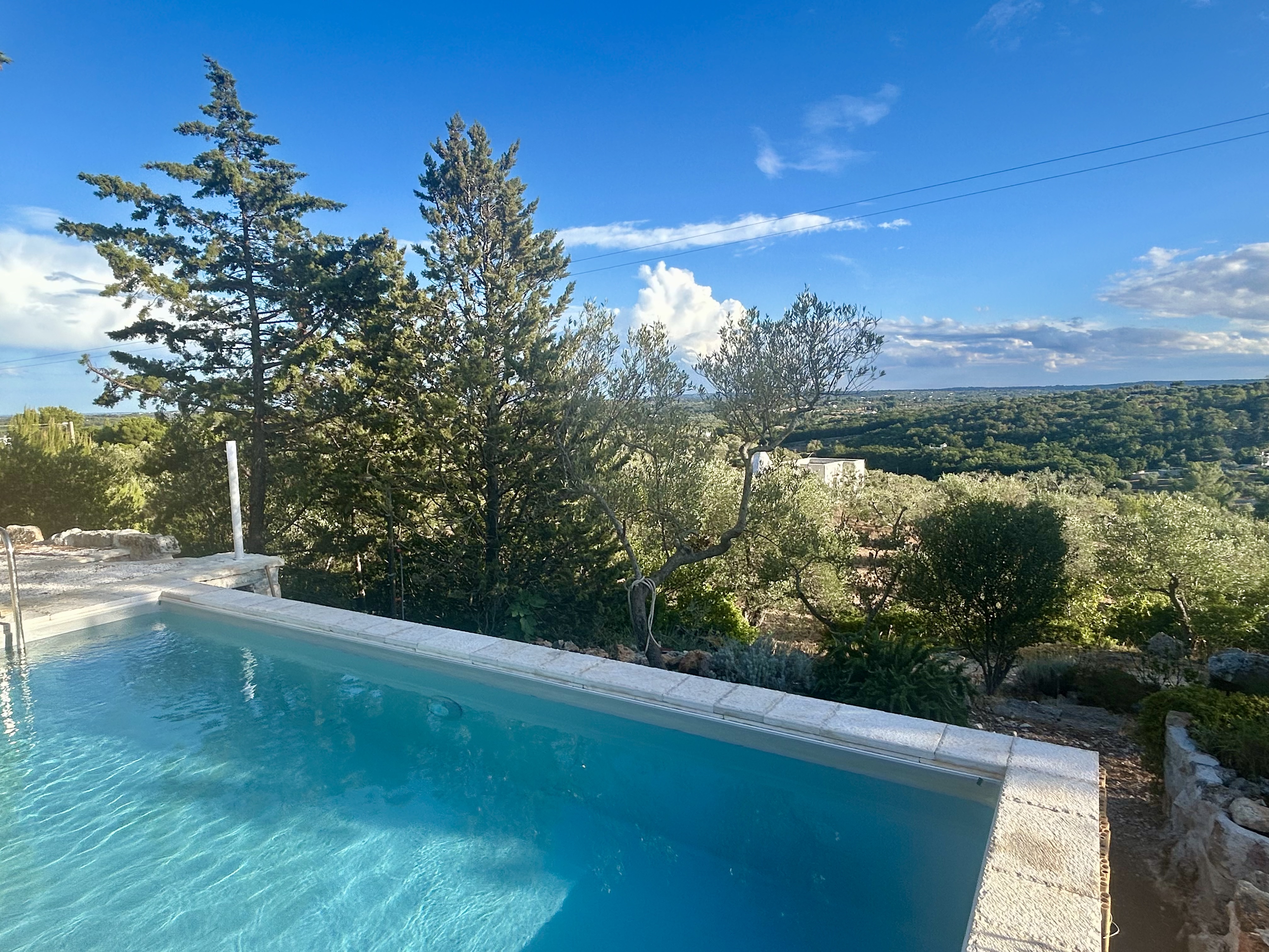 Piscina fuori terra Astrea in giardino con vista sulla valle e vegetazione lussureggiante